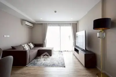 Modern living room with sleek furniture and large TV, featuring a cozy sofa and elegant decor.