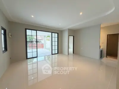 Spacious modern living room with large windows and glossy tiled floors