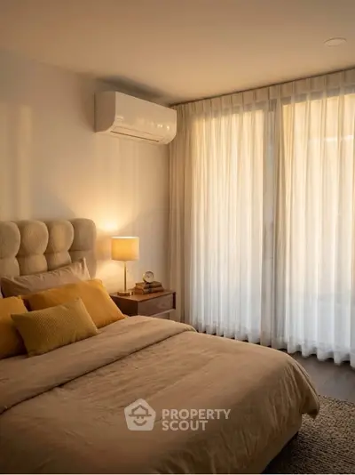 Cozy bedroom with soft lighting and elegant curtains, featuring a plush bed and modern air conditioning unit.