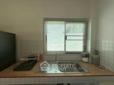 Modern kitchen with sleek sink and window, perfect for culinary enthusiasts.