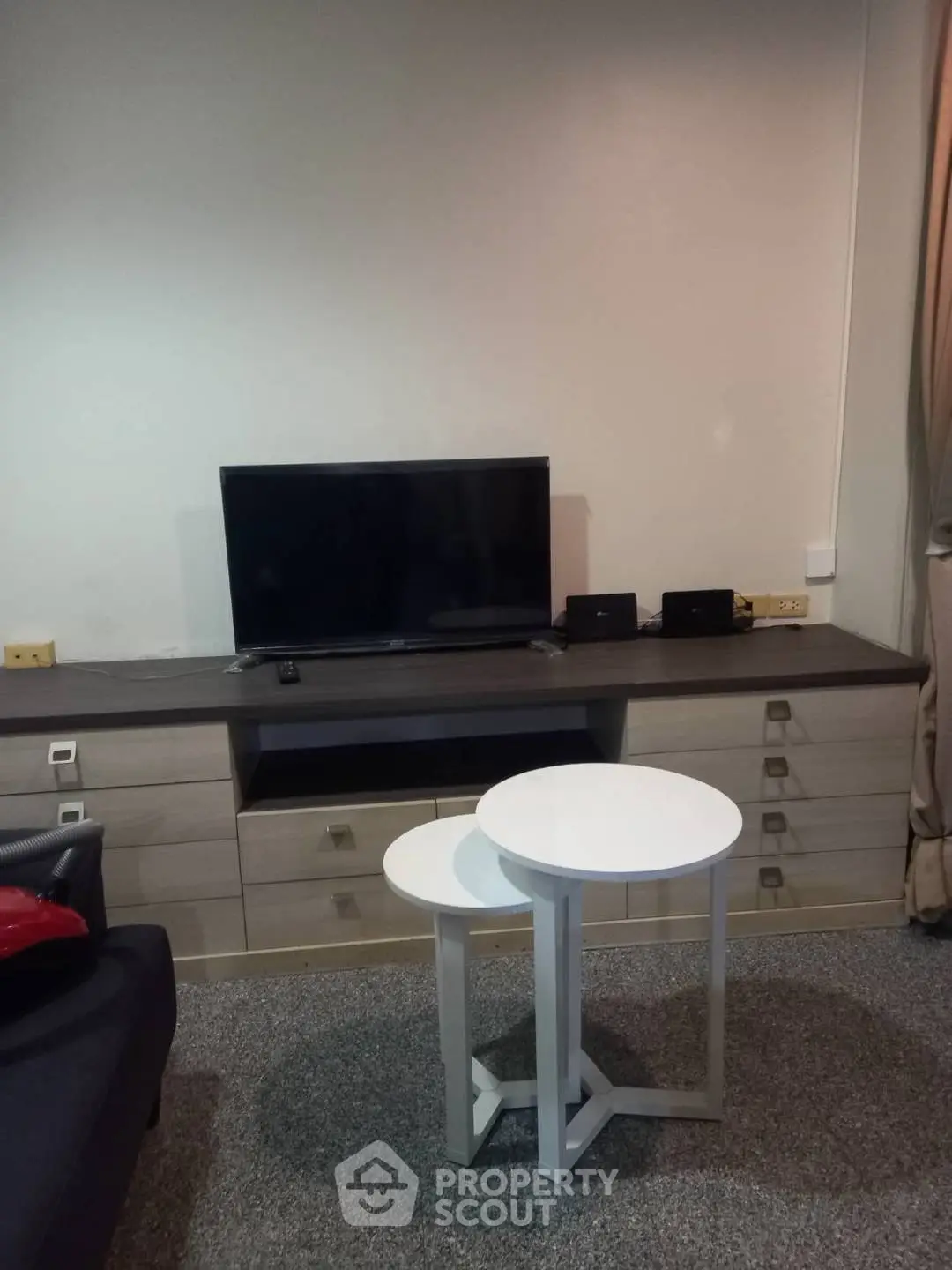 Modern living room with sleek TV setup and stylish nesting tables.