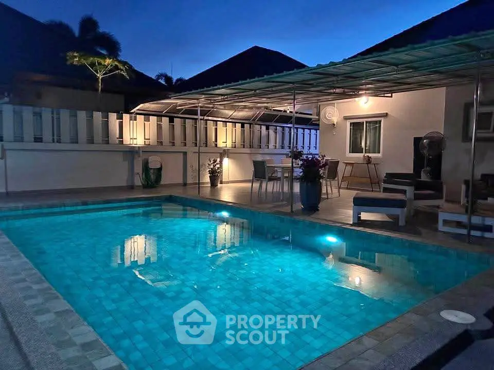 Stunning evening poolside view with elegant outdoor seating and ambient lighting.