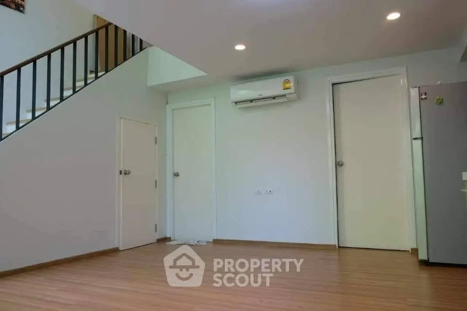 Spacious modern living room with wooden flooring and air conditioning