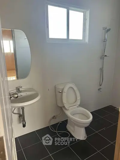Modern bathroom with sleek fixtures and a window for natural light.