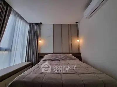 Cozy bedroom with modern lighting and air conditioning, featuring a comfortable bed and large window.