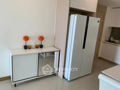 Modern kitchen with sleek refrigerator and stylish decor in a contemporary apartment.
