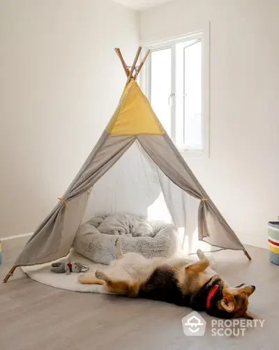 Cozy bedroom with playful tent and relaxed dog, perfect for family living.