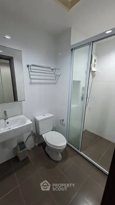 Modern bathroom with glass shower and sleek fixtures in a contemporary apartment.