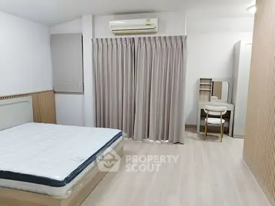 Modern minimalist bedroom with air conditioning and stylish furniture.