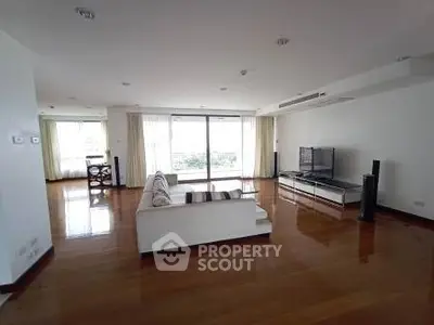 Spacious living room with modern decor and large windows offering natural light.