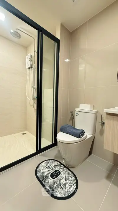 Modern bathroom with glass shower and sleek fixtures in contemporary apartment.