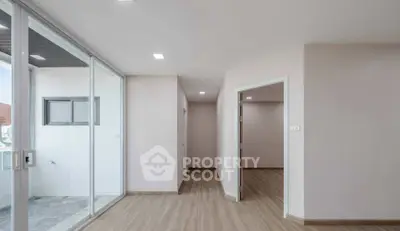 Spacious modern apartment interior with sleek wooden flooring and large windows for natural light.