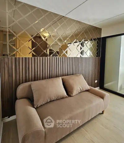 Modern living room with stylish sofa and mirrored accent wall