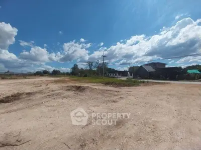 Expansive vacant land with clear blue sky, perfect for development opportunities.