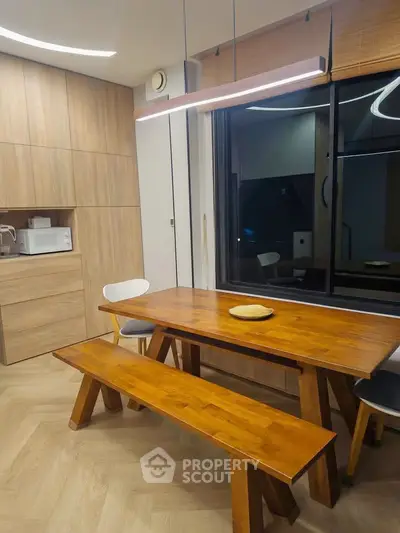Modern kitchen with wooden dining table and built-in microwave