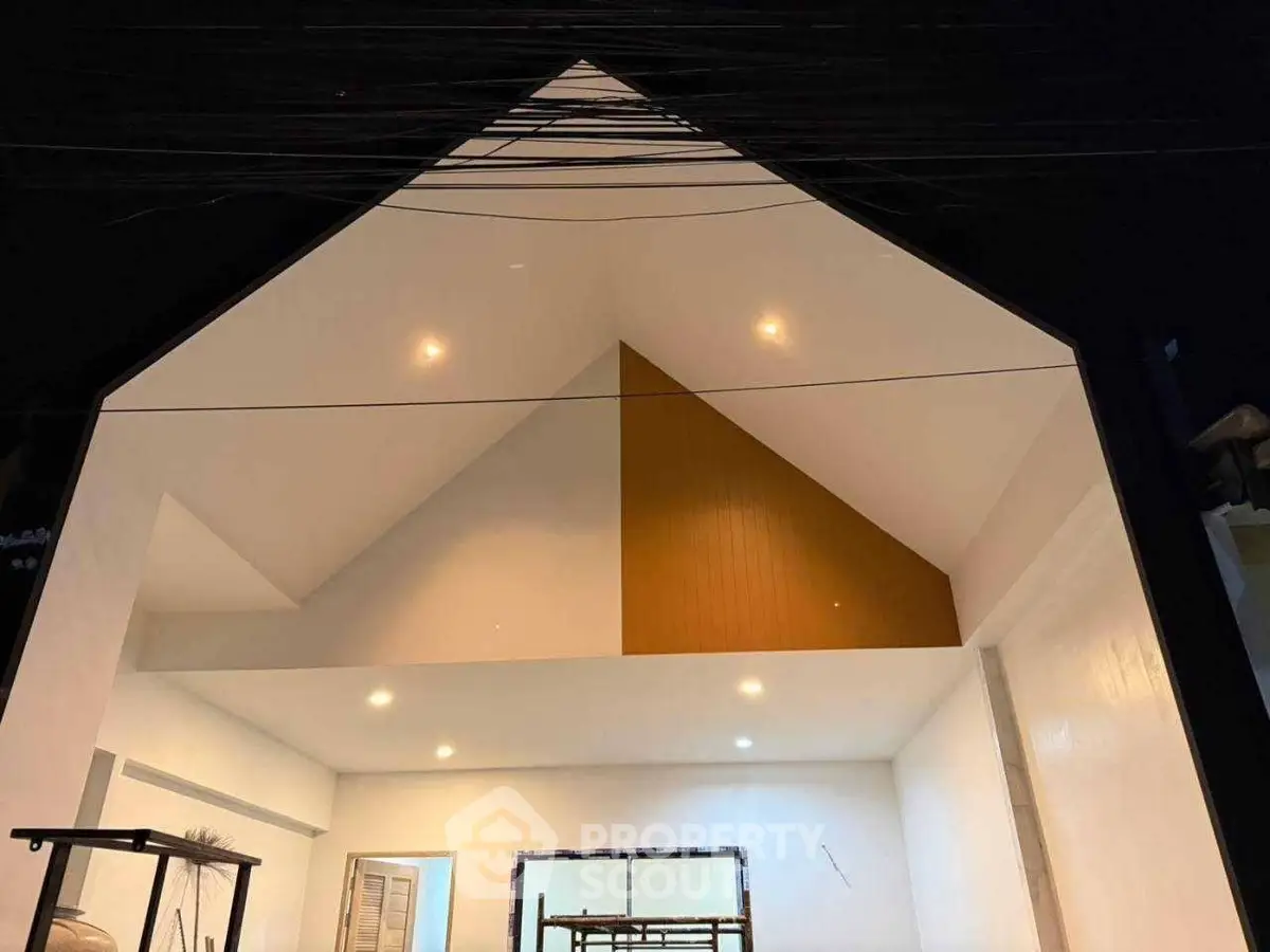 Modern architectural exterior with unique geometric roof design and ambient lighting.