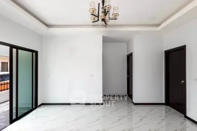 Spacious modern living room with elegant chandelier and marble flooring