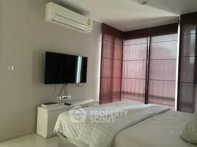 Modern bedroom with air conditioning and wall-mounted TV, featuring sleek design and natural light.