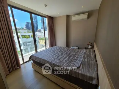 Modern bedroom with large window and city view, featuring air conditioning and stylish decor.