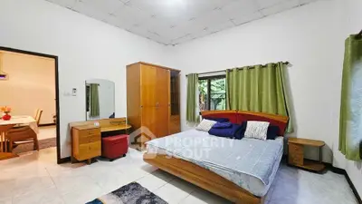 Spacious bedroom with wooden furniture and natural light in a cozy home.