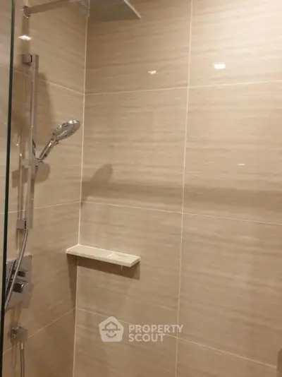 Modern bathroom shower area with sleek tiles and glass partition