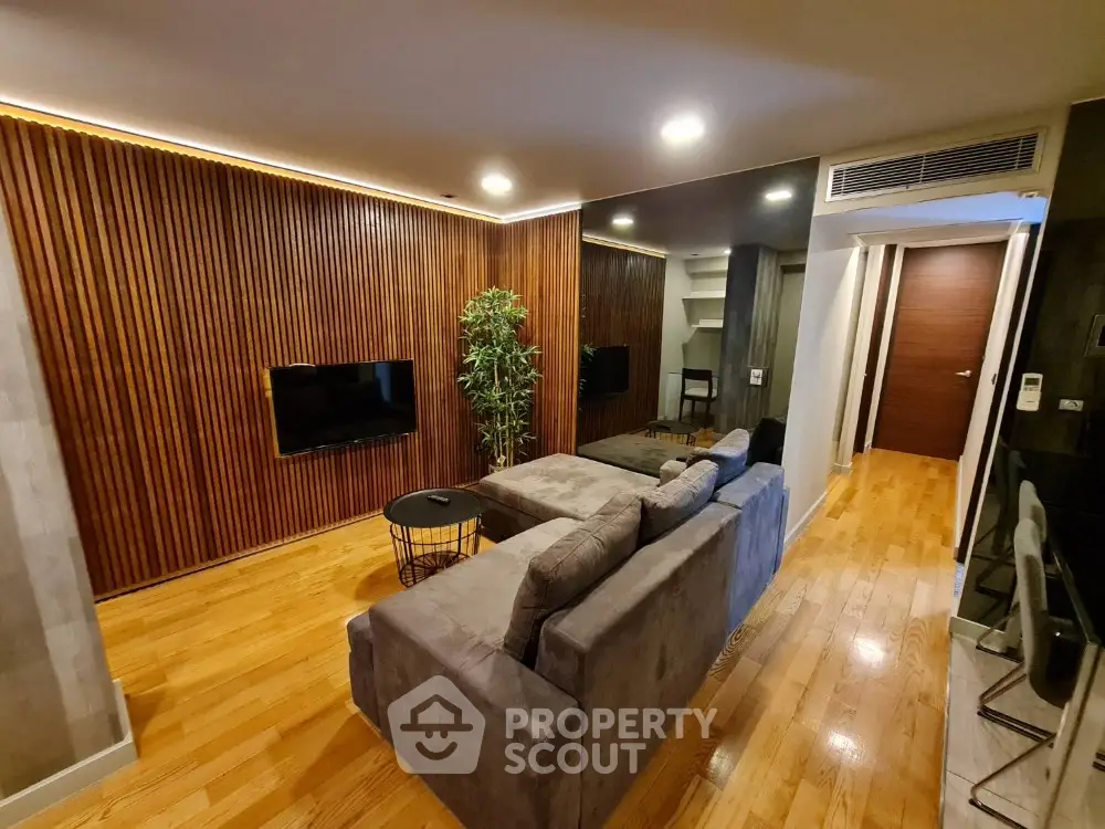 Modern living room with wooden accent wall and cozy gray sofa