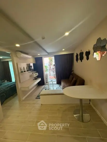 Modern living room with stylish decor and natural light, featuring a cozy sofa and wall-mounted shelves.