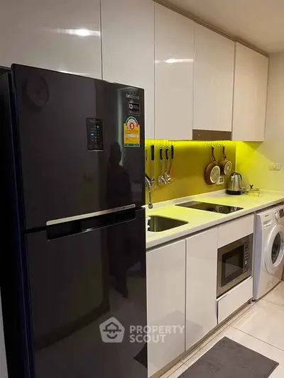 Modern kitchen with sleek appliances and bright yellow backsplash