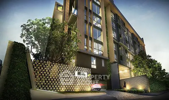 Modern apartment building exterior with lush greenery and stylish entrance.