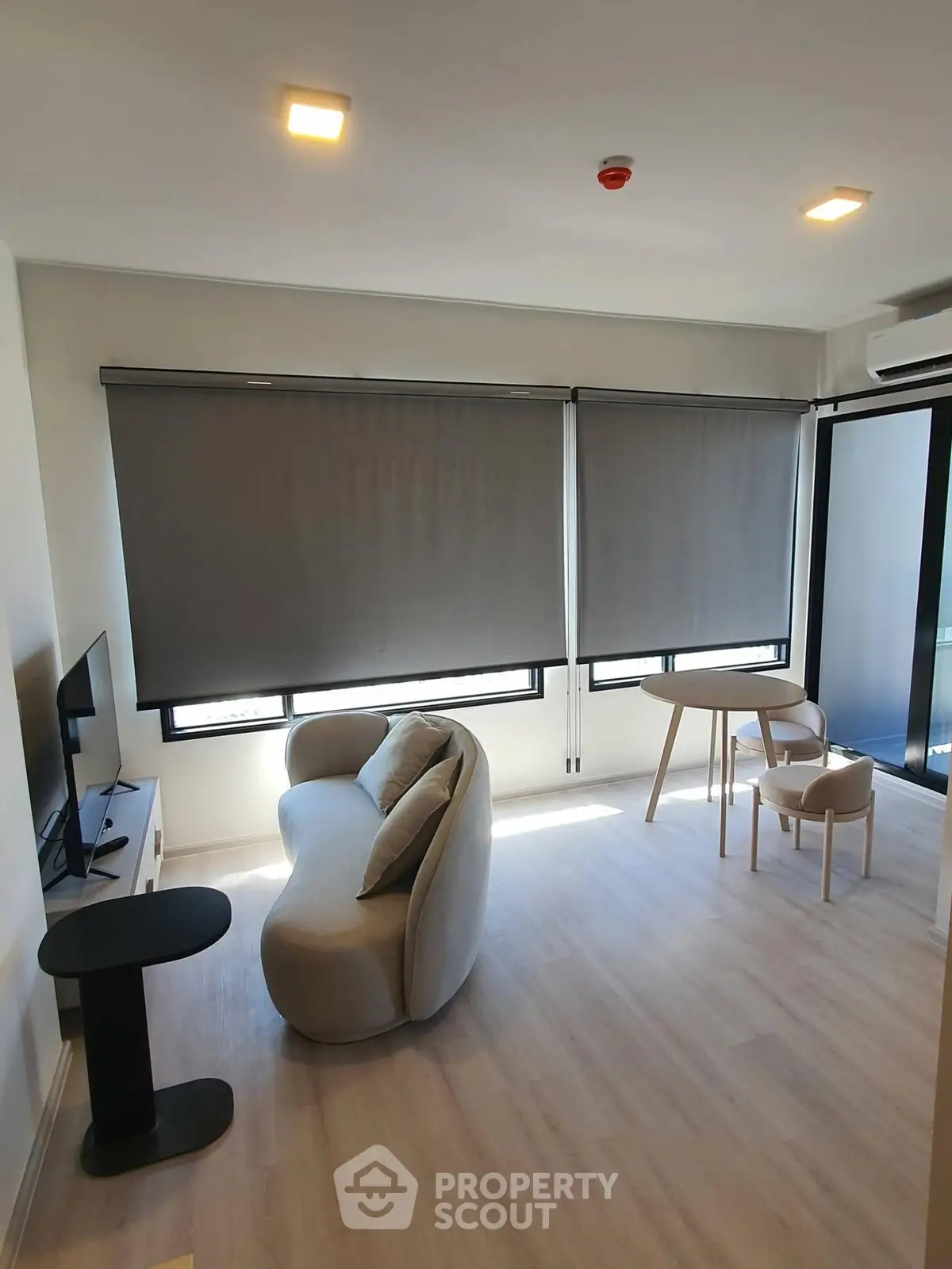 Modern living room with sleek furniture and large windows in a stylish apartment.