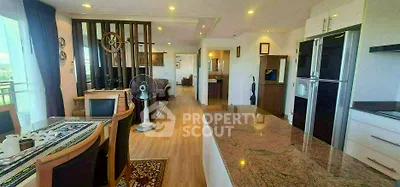 Spacious open-plan living and dining area with modern kitchen and elegant decor.