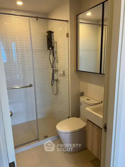Modern bathroom with glass shower enclosure and sleek fixtures