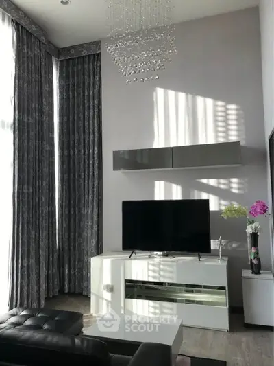 Elegant living room with high ceilings, modern furniture, and natural light.