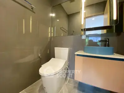 Modern bathroom with sleek fixtures and stylish design, featuring a contemporary toilet and elegant sink.