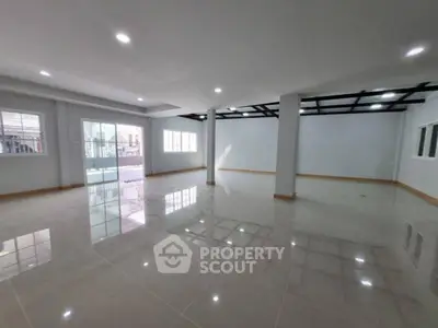 Spacious open-plan interior with glossy floors and large windows, perfect for versatile living or office space.