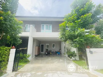 Modern two-story house with lush greenery and spacious driveway