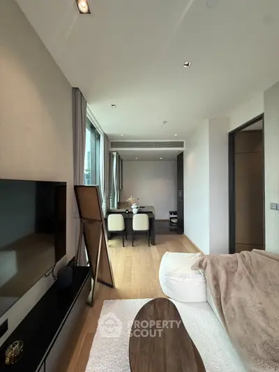 Modern living room with sleek design and cozy seating area, featuring large windows and stylish decor.