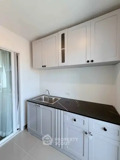 Modern kitchen with sleek cabinetry and dual sink in a bright, minimalist design.