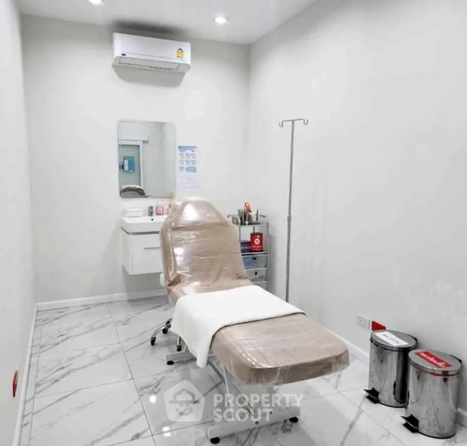 Modern medical room with sleek design and marble flooring, featuring a comfortable examination chair.