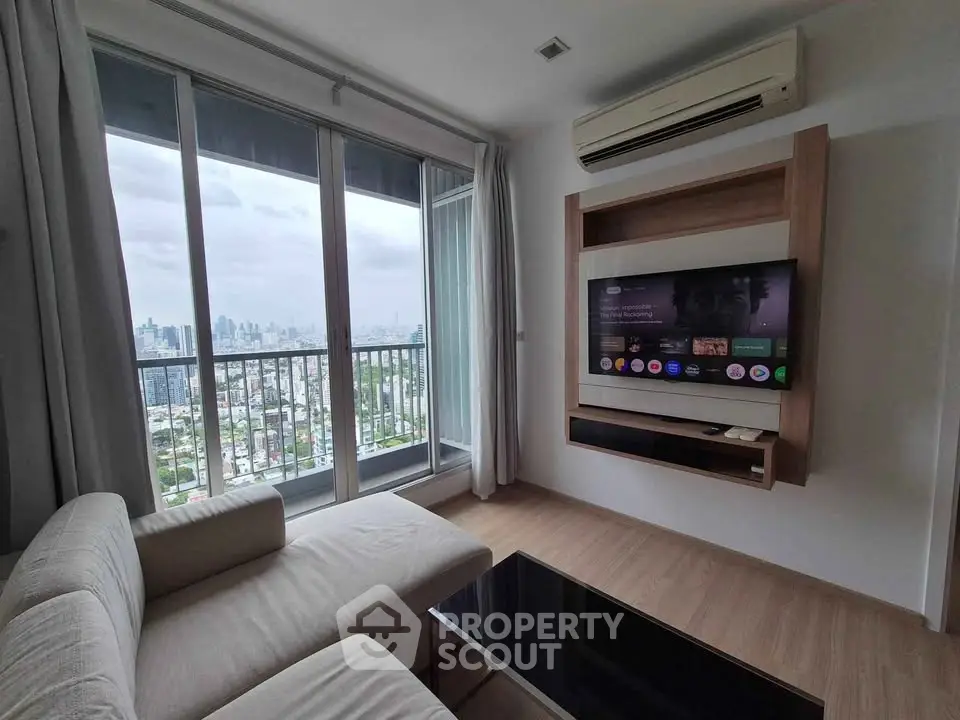 Modern living room with city view, featuring sleek furniture and wall-mounted TV, perfect for urban living.