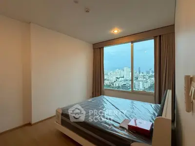 Modern bedroom with city view and large window in high-rise apartment