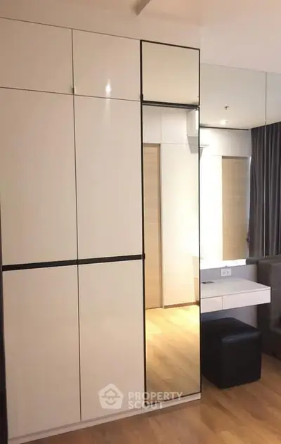 Modern bedroom with sleek built-in wardrobe and stylish vanity area.