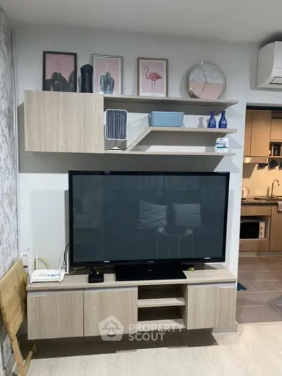 Modern living room with stylish wooden TV unit and open kitchen layout, perfect for cozy urban living.