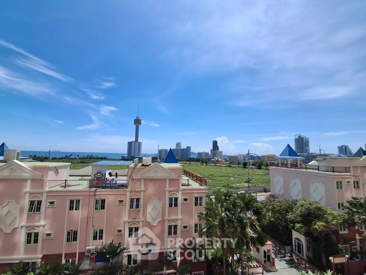 Stunning cityscape view from a pink residential building with lush greenery and skyline backdrop.