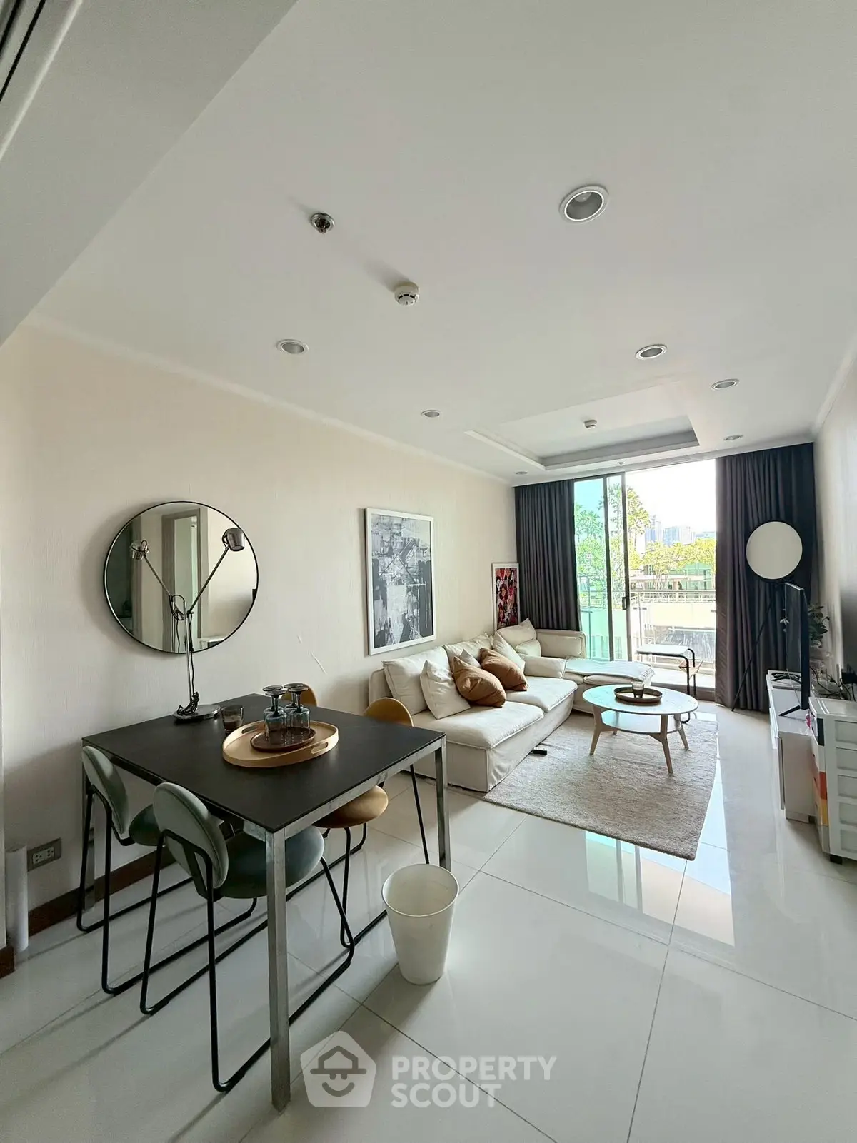 Spacious modern living room with large windows and stylish decor, perfect for relaxation and entertaining.