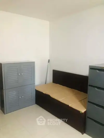 Minimalist bedroom with simple bed and storage cabinets, ideal for compact living spaces.