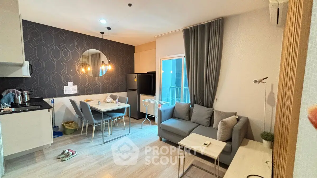 Modern living room with open kitchen, stylish decor, and cozy seating area in a contemporary apartment.