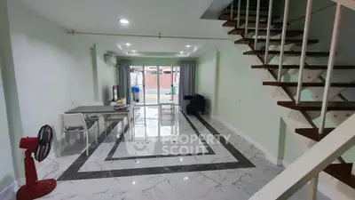 Spacious modern living room with stylish staircase and elegant marble flooring.