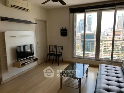 Modern living room with city view, featuring sleek furniture and large windows for natural light.