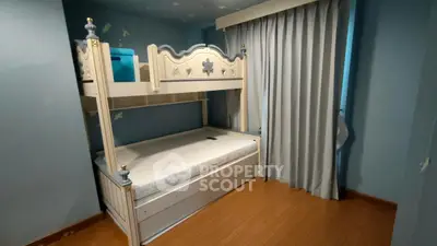 Charming bedroom with stylish bunk bed and elegant curtains in cozy setting.